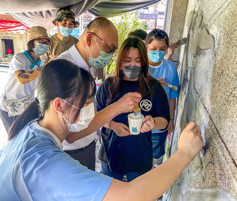 在剪黏藝術師、簡淑慧女士及美術老師指導下，校長與學生一起創作土地公意象之剪粘文化藝術牆