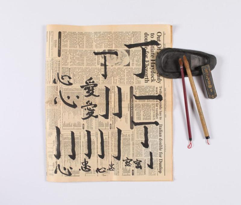 蘭大弼在報紙上練習中文（原作名稱：毛筆座、硯台、墨與習字報紙。典藏者：彰基文史博物館。發佈於《彰基文史博物館文史資料庫》[https://cchhmuseum.org/archive/detail.php?sid=1379]）照片提供者：彰基文史博物館藏／拍攝年份：1954