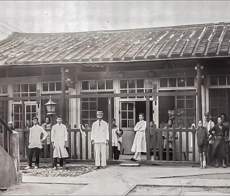 第一代彰基後棟（原作名稱：1910年代第一代醫院後棟一層樓建築及病人。典藏者：彰基文史博物館。發佈於《彰基文史博物館文史資料庫》[http://cchhmuseum.org/archive/detail.php?sid=926]）照片提供者：彰基文史博物館藏／拍攝年份：1910