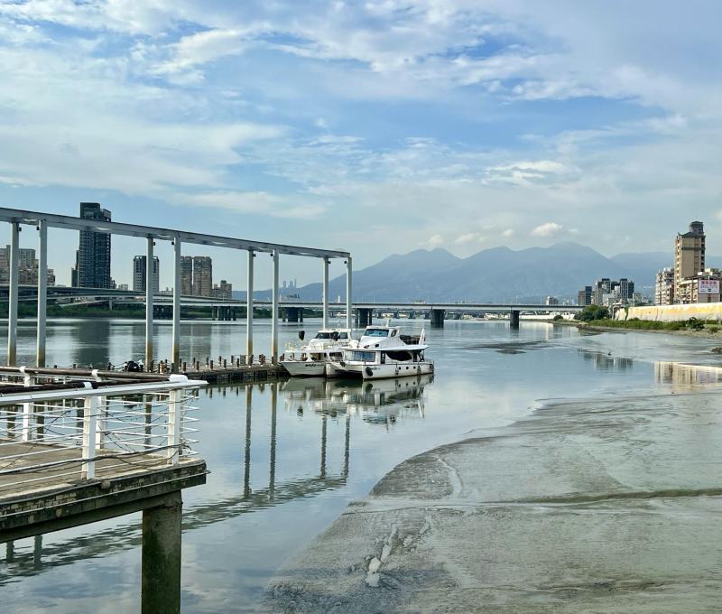 從大稻埕碼頭眺望臺北橋、大屯山。(照片提供者:毛毓翔 / 拍攝日期:2025/08/21) 從大稻埕碼頭眺望臺北橋、大屯山。(照片提供者:毛毓翔 / 拍攝日期:2025/08/21)